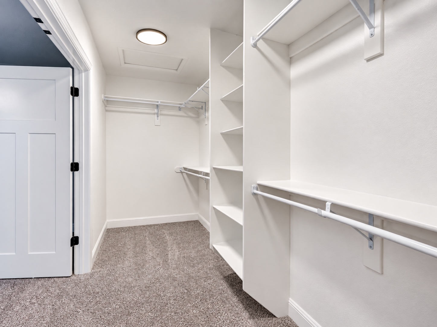 White built-in closet shelves with hanging rods and matching interior door trim